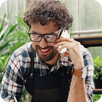 Florist takes a phone call inside his greenhouse    